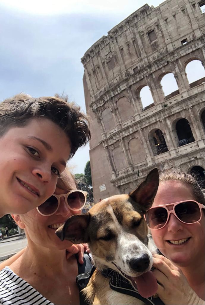 Family and dog taking a selfie in front of the Colosseum in Rome
