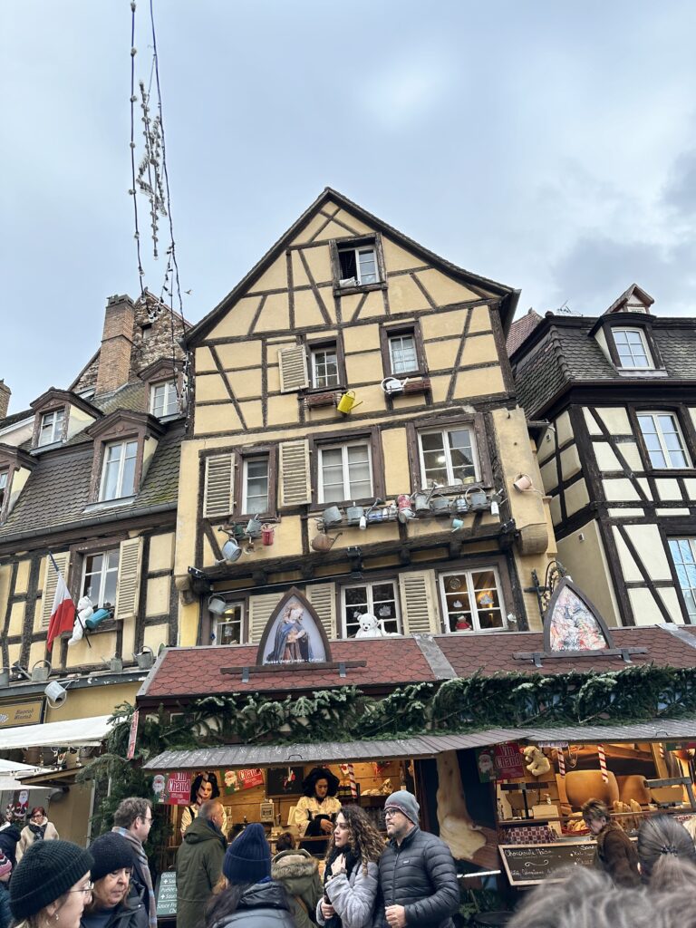 Vin chaud stall below a decorated half-timbered building in Colmar