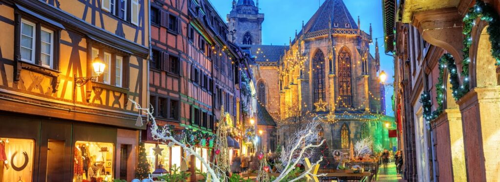 Christmas lights and half-timbered buildings near the church in Colmar, France