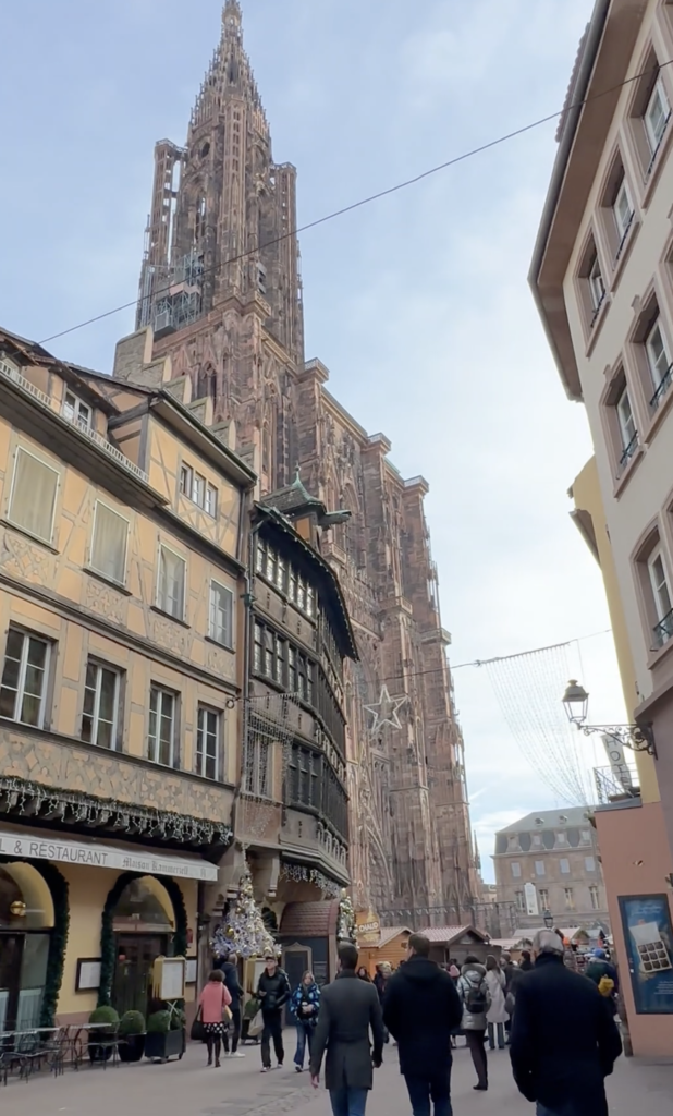 Strasbourg Cathedral rising above decorated streets and Christmas market stalls