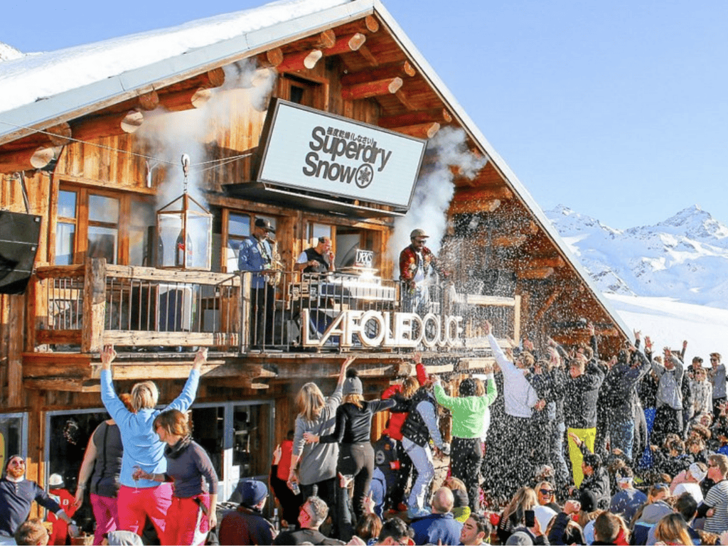 Après-ski fun in Méribel, France, with skiers dancing on tables and enjoying a lively alpine atmosphere.