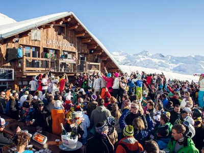 Après-ski festivities in Val d’Isère, France, with skiers celebrating at an outdoor bar in the mountains.