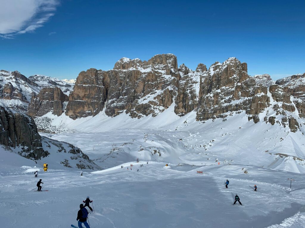 Skiers on snowy slopes beneath the Dolomite mountains in Cortina d’Ampezzo, Italy
