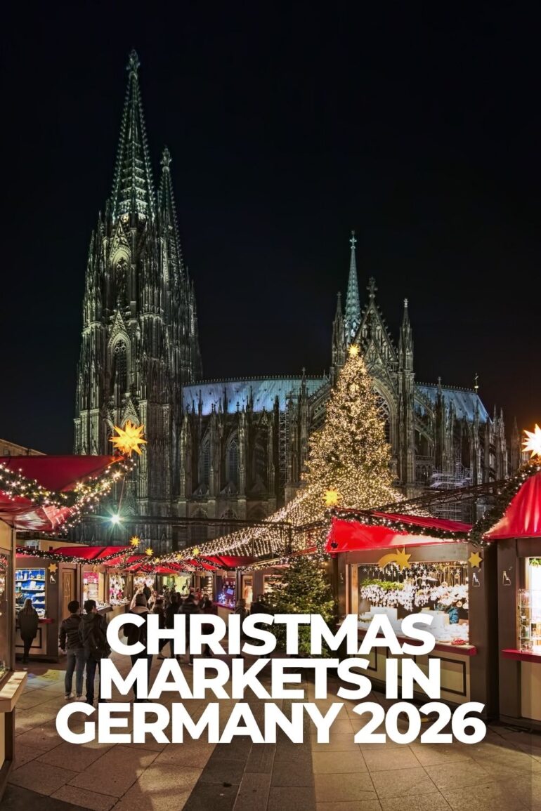 Cologne Christmas market at night with Cologne Cathedral, illuminated market stalls and a large Christmas tree