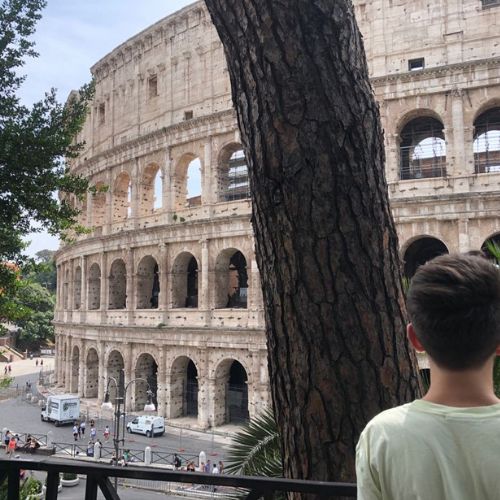 Teen looking at the Colosseum from a shaded viewpoint in Rome