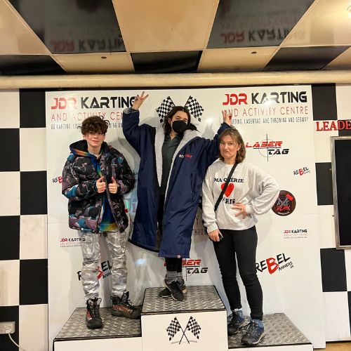 Family standing on the podium at JDR Karting in Gloucester after finishing their races.