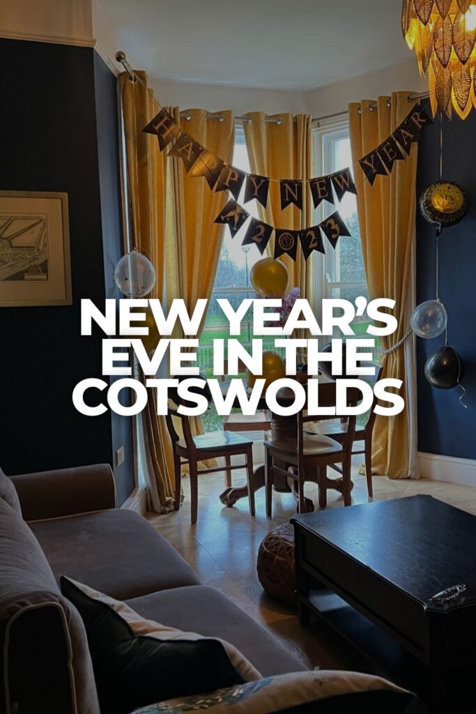 Airbnb living room in Gloucester decorated for New Year’s Eve with gold curtains, balloons, and a Happy New Year banner.