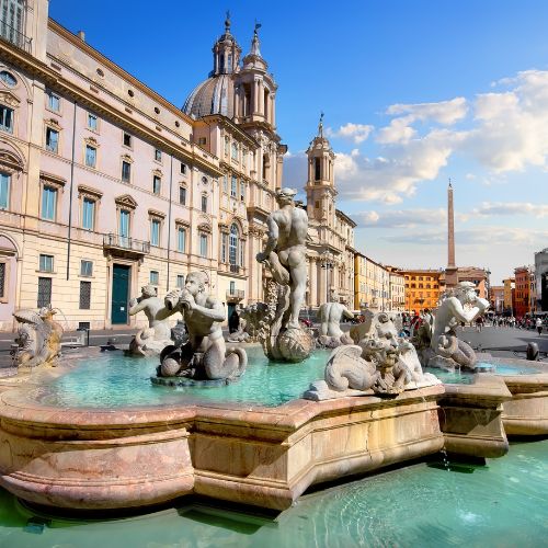 Piazza Navona fountain with historic buildings and blue sky in Rome