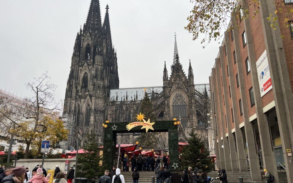 Cathedral skyline from across the Rhine or Cathedral with Christmas market stalls in front.