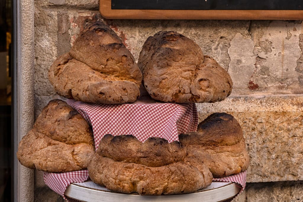 Pane di Matera, the traditional durum wheat sourdough bread with IGP protected status, displayed outside a bakery in Matera