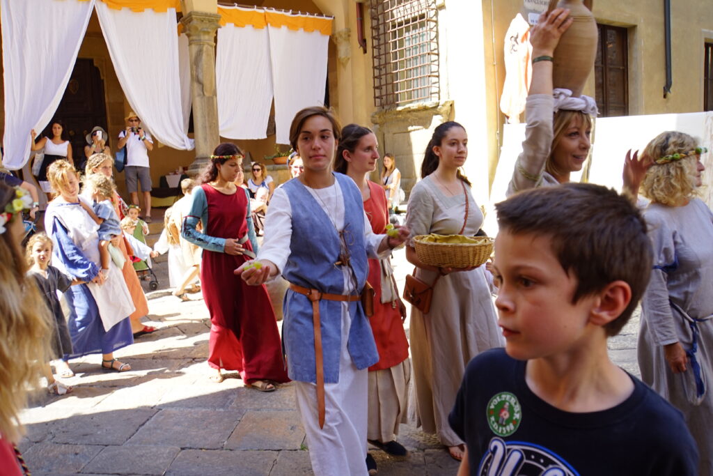 Costumed performers parading through Volterra during the AD 1398 festival