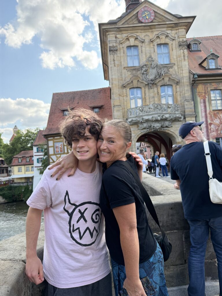 Erin and Dylan standing on a bridge in Bamberg with the half-timbered houses of Little Venice behind them