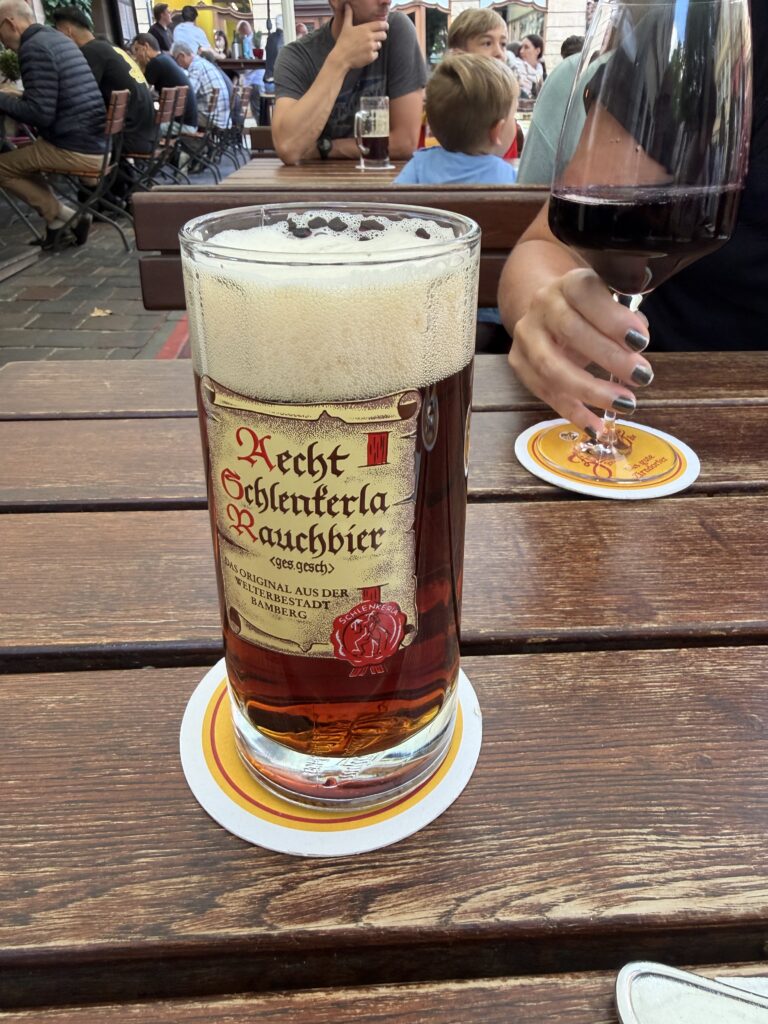Glass of Aecht Schlenkerla Rauchbier beside the beer menu in Bamberg