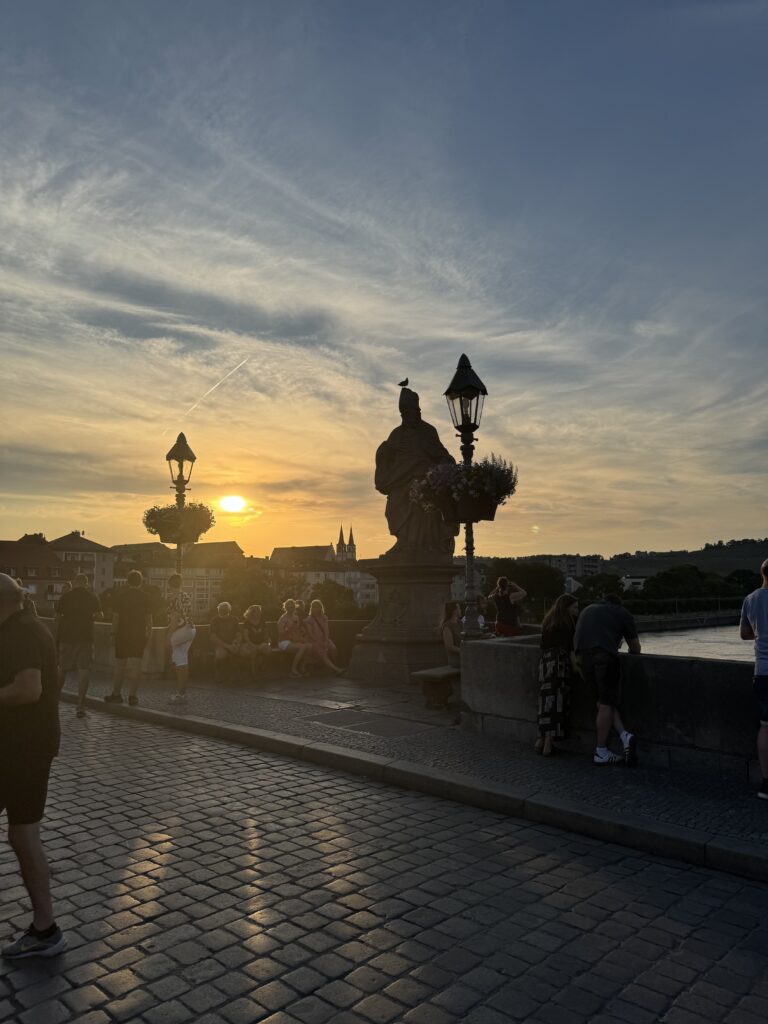 Baroque statue silhouetted at sunset on Würzburg’s Old Main Bridge