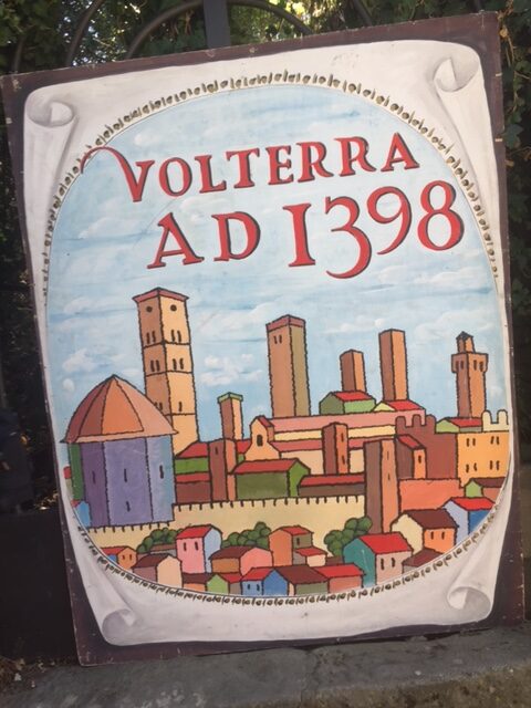 Volterra AD 1398 festival sign with hand-painted town skyline
