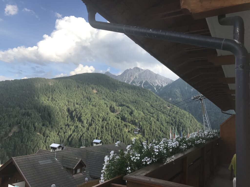 Cable car crossing a forested mountain valley in South Tyrol