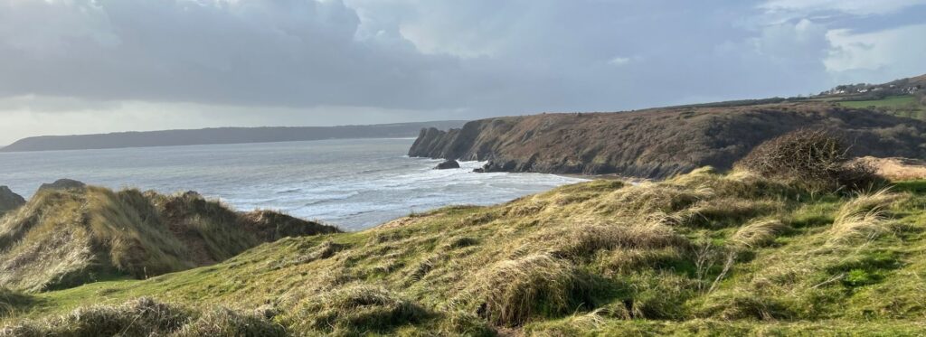 Winter view of the Gower Peninsula coastline in South Wales with grassy cliffs and the sea