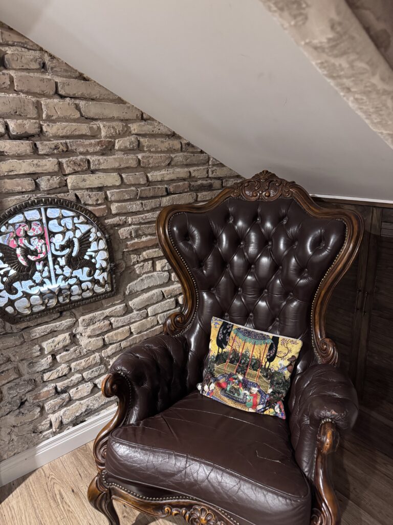 Antique leather armchair beside exposed brick walls inside an apartment in Vilnius Old Town