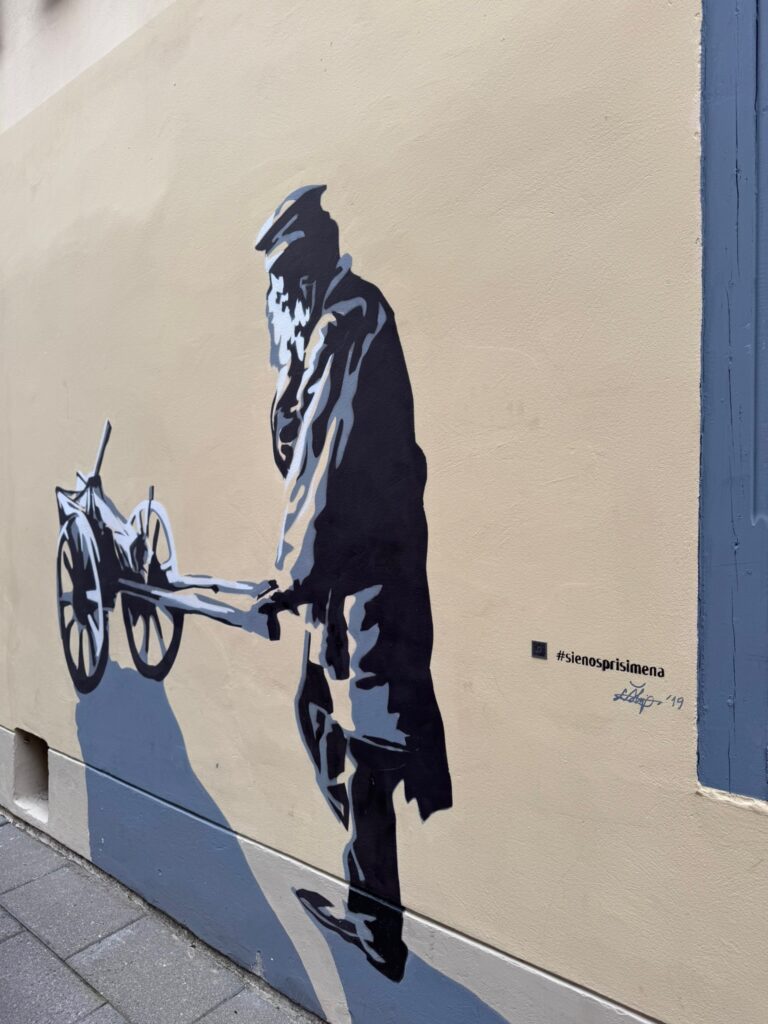 Black and white street art mural depicting a historical Jewish resident as part of the Walls That Remember project in Vilnius