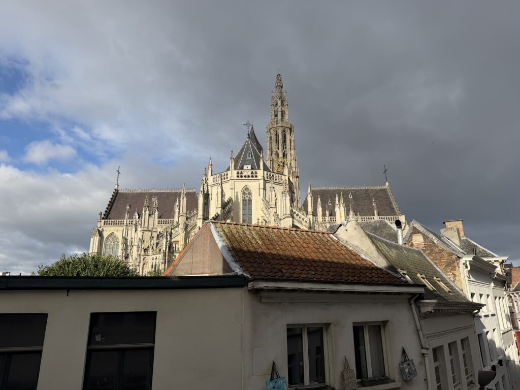 View of the illuminated Cathedral of Our Lady above rooftops from our Antwerp Airbnb