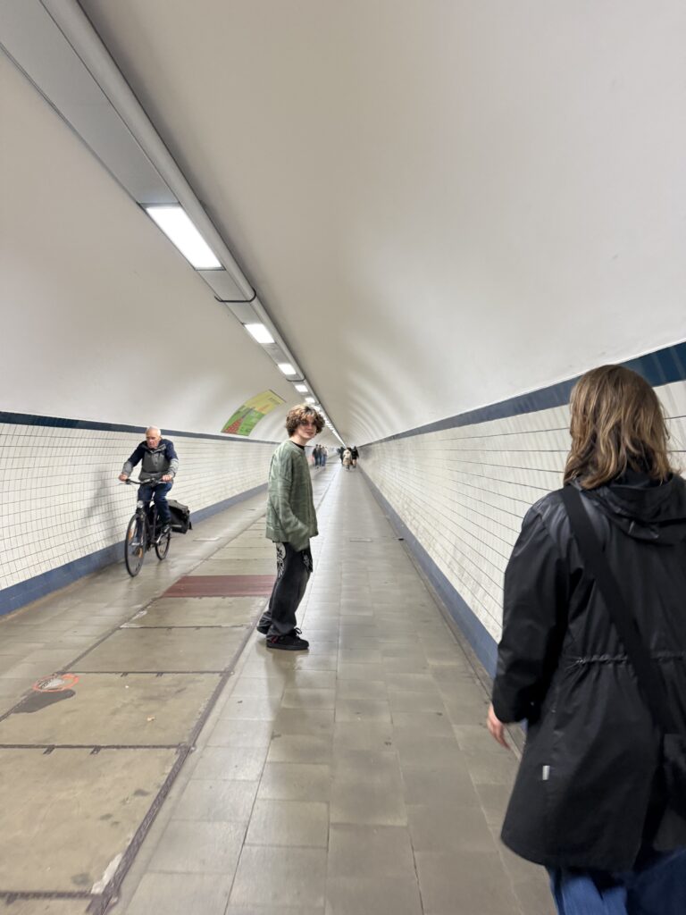Long white tiled pedestrian tunnel beneath the Scheldt River in Antwerp