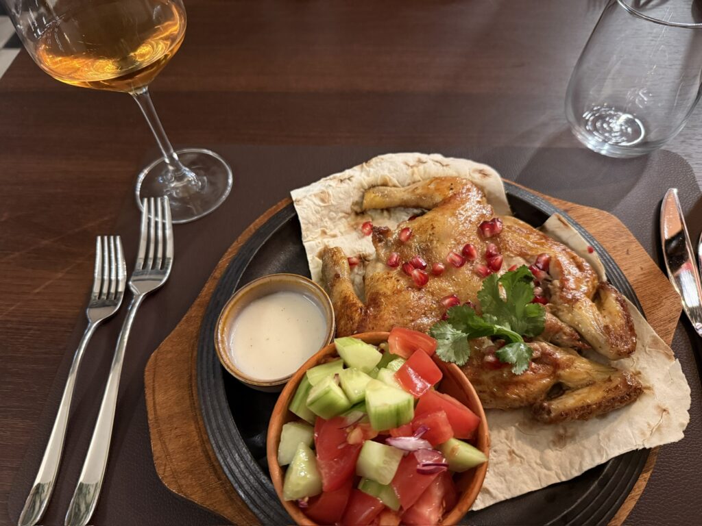 Spatchcocked roast chicken on flatbread with pomegranate seeds at Kvevri Georgian restaurant in Vilnius