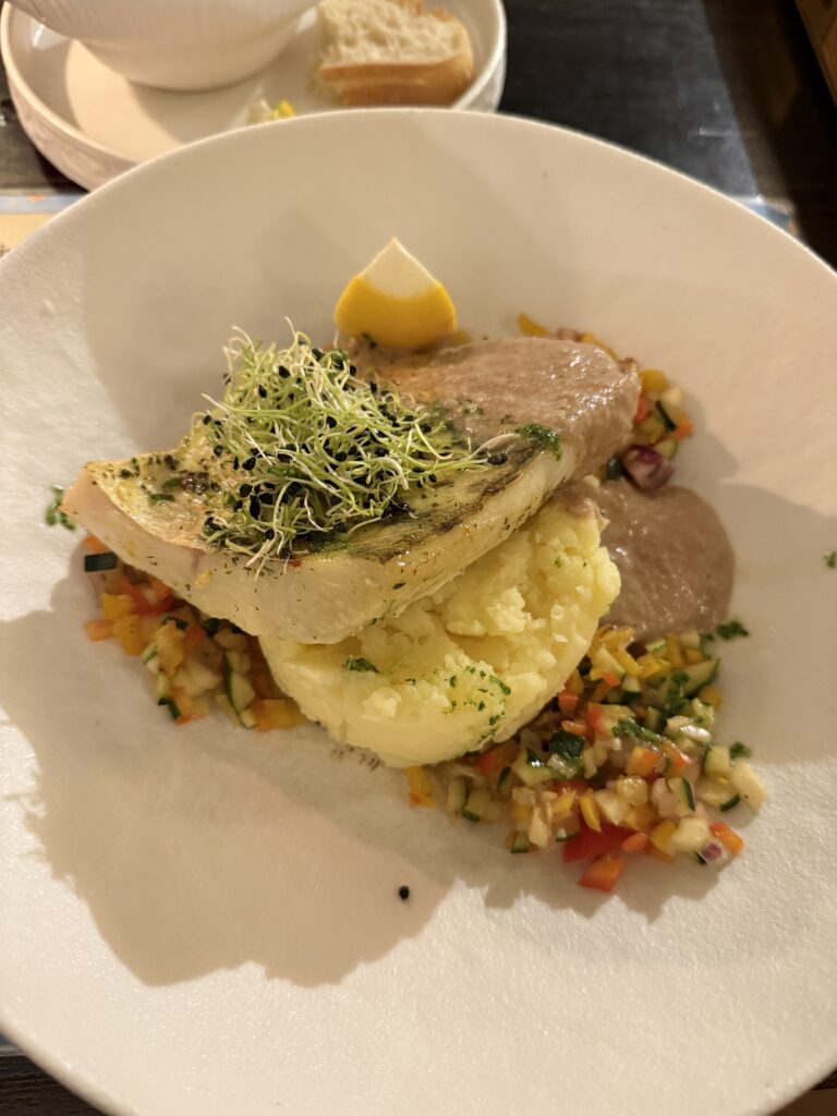Pikeperch fillet with caramelized onion sauce over mashed potatoes at Bernelių Užeiga in Vilnius
